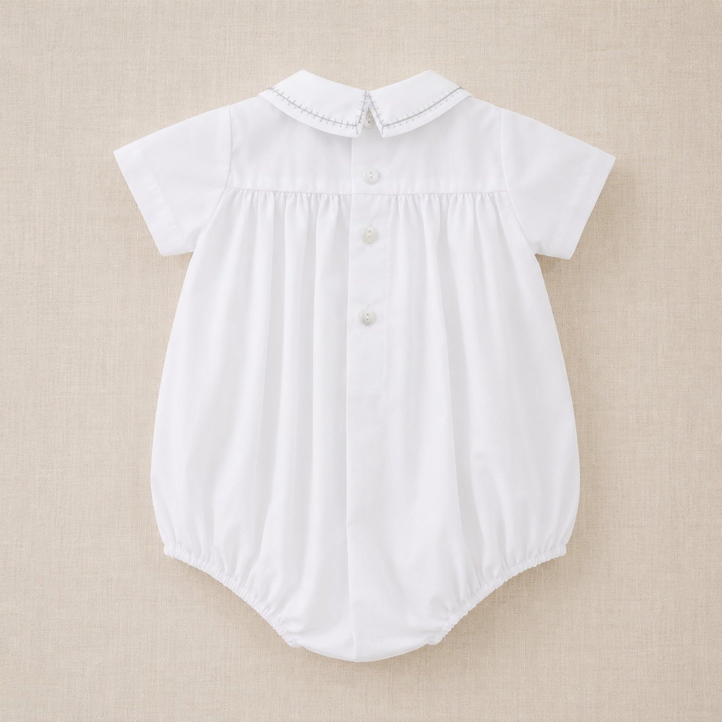 Vista posterior de bombacho de algodón blanco bordado a mano para bebé niño, ideal para bautizo y ceremonias.